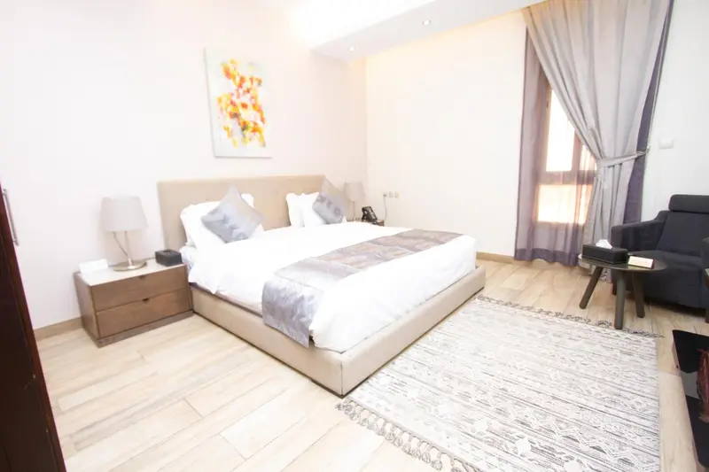 Une chambre lumineuse avec un grand lit et un coin salon.