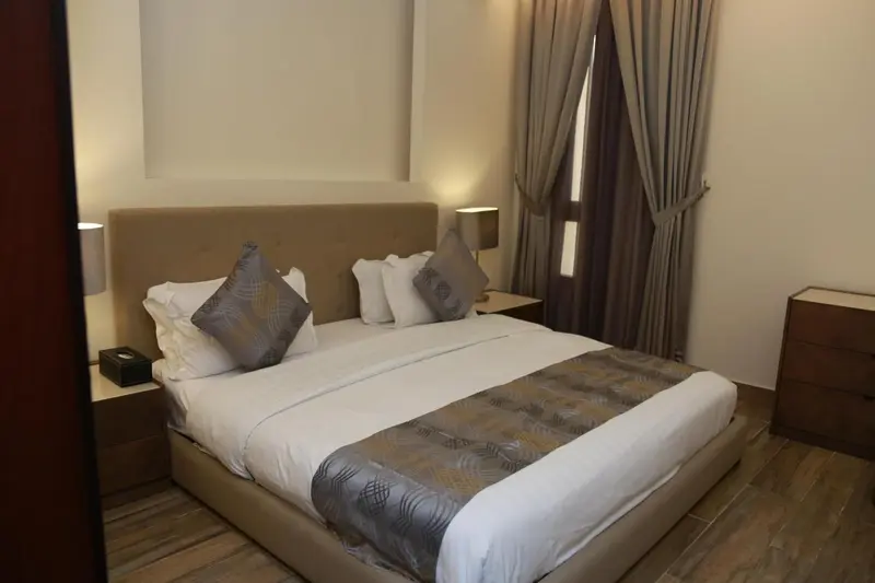 Une chambre lumineuse avec un grand lit et des tables de chevet.
