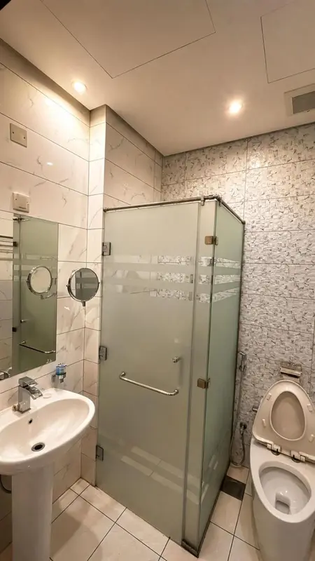 Une salle de bain moderne avec douche vitrée et sanitaires.