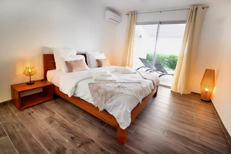 Une chambre lumineuse avec un grand lit et un accès à une terrasse.