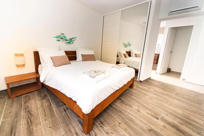 Une chambre lumineuse avec un grand lit recouvert de draps blancs.