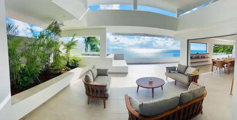 Espace de détente intérieur avec canapés et vue sur la mer.