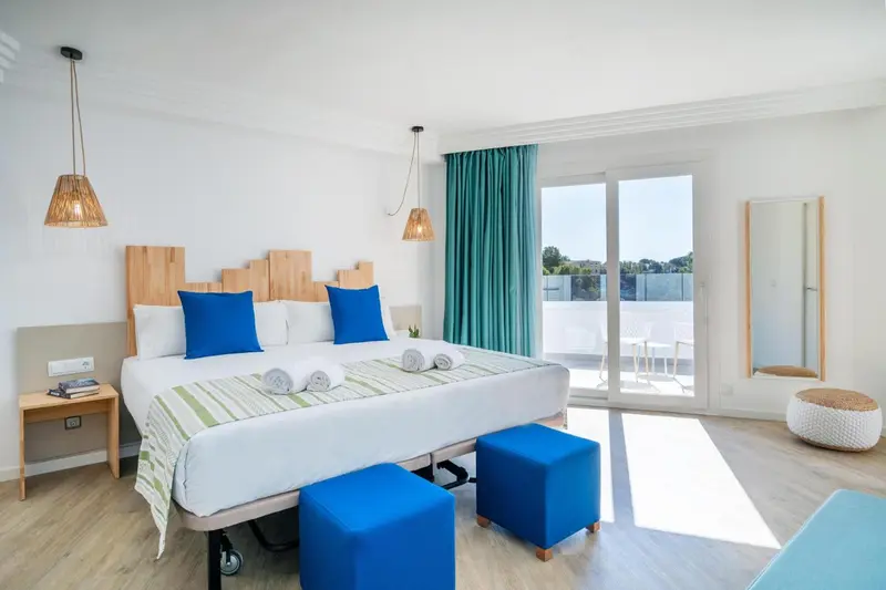Une chambre lumineuse avec un grand lit et un accès à une terrasse.