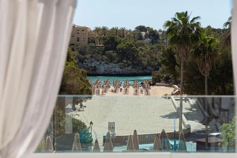 Vue sur une plage de sable fin et une crique abritée.