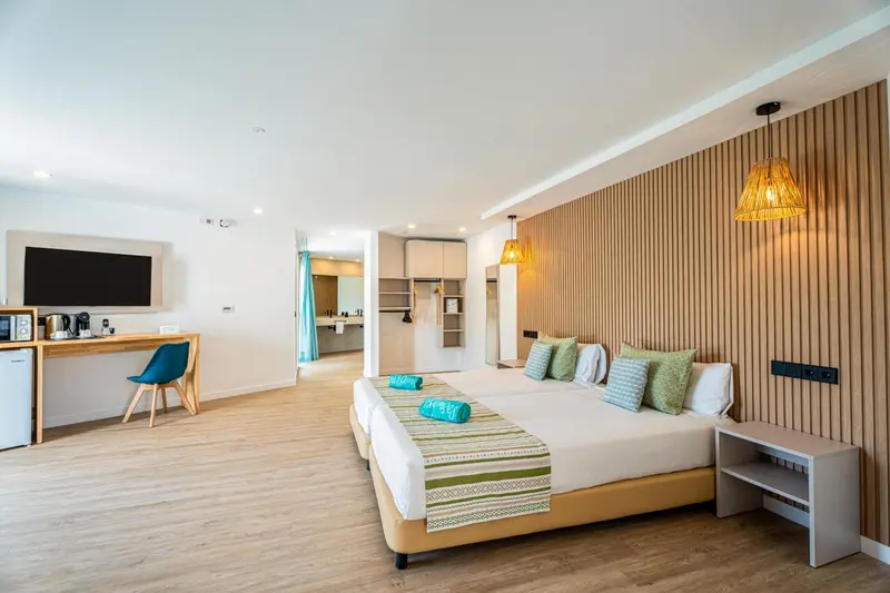 Une chambre lumineuse avec un grand lit et un espace bureau.