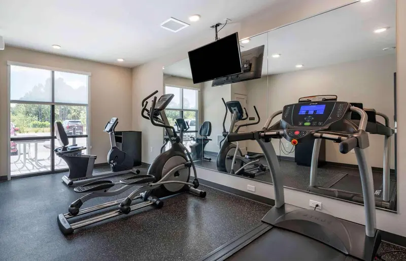 Une salle de sport avec des équipements de fitness et un grand miroir.