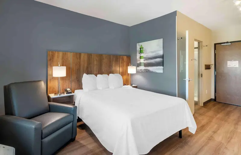Une chambre d'hôtel moderne avec un grand lit et un fauteuil.