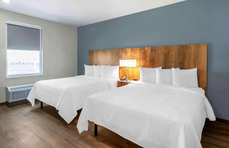 Une chambre d'hôtel avec deux lits simples et une décoration sobre.