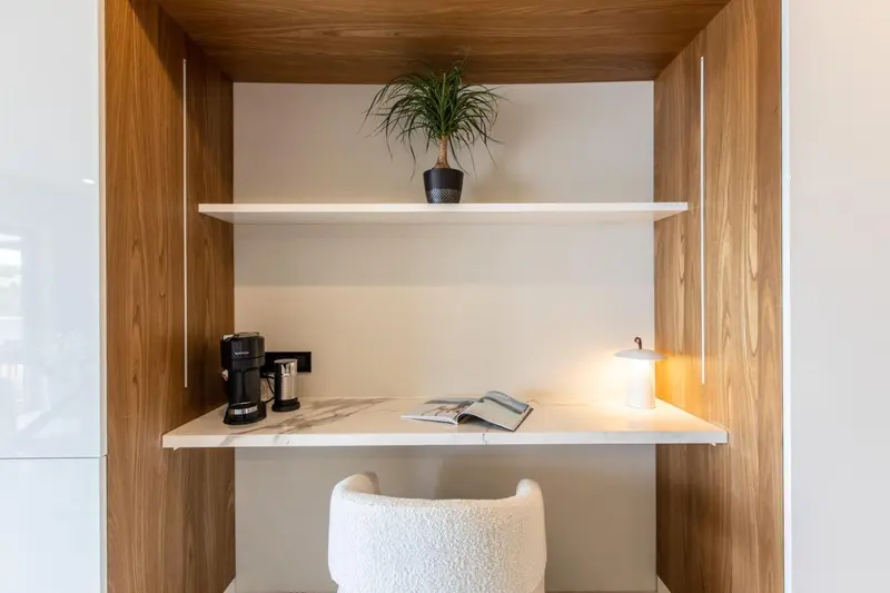 Un espace bureau avec une machine à café et une lampe sur un plan de travail.