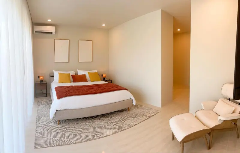 Une chambre lumineuse avec un grand lit et un coin salon.