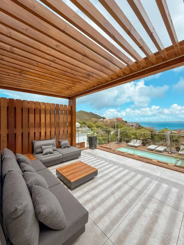 Espace de détente extérieur avec canapés et petite piscine.