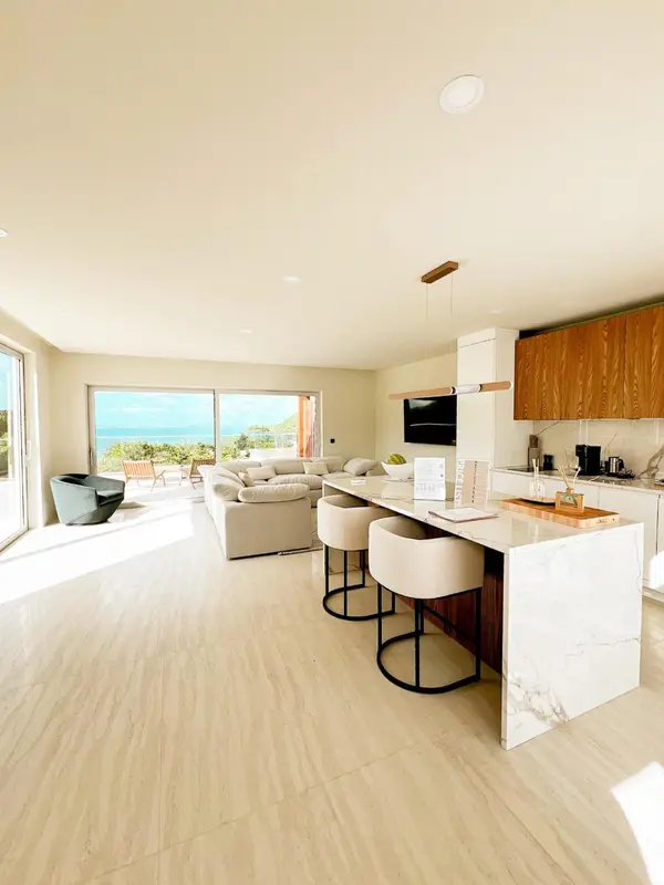 Espace de vie lumineux avec cuisine ouverte et vue sur la mer.