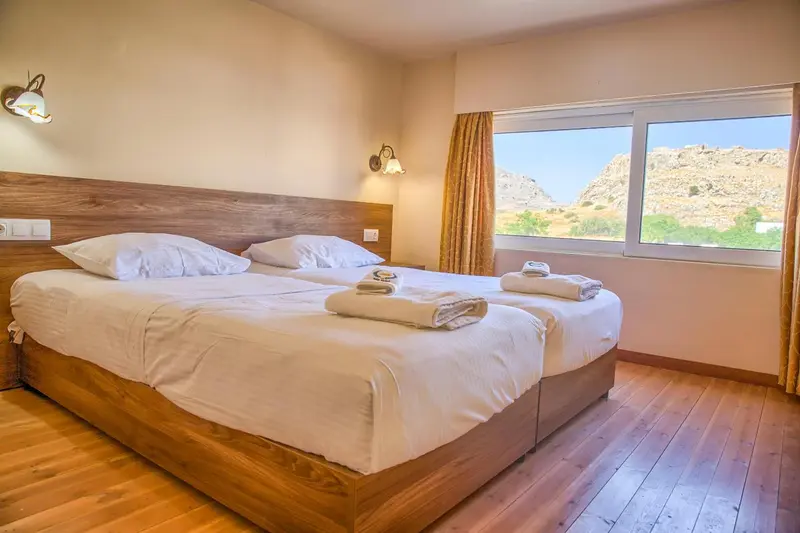Une chambre lumineuse avec un grand lit et une vue sur les montagnes.