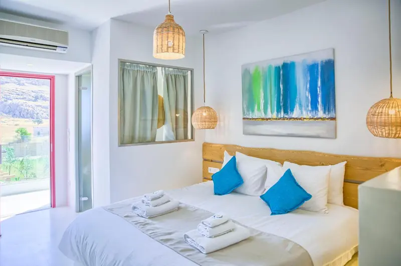 Une chambre lumineuse avec un grand lit et une décoration moderne.