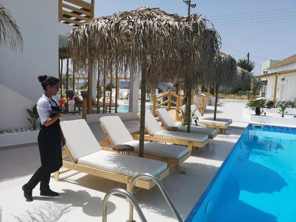 Une serveuse porte des boissons à des clients près d'une piscine.