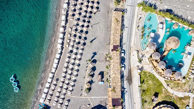 Vue aérienne d'une plage avec des transats et une piscine.