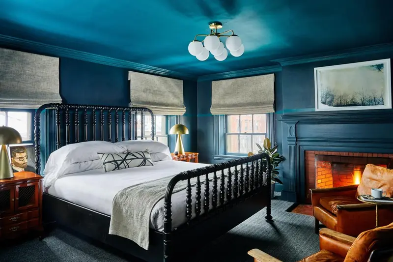 Une chambre à coucher avec un lit recouvert d'une courtepointe blanche et d'oreillers.