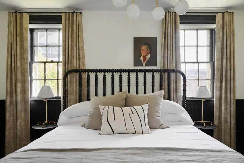 Une chambre à coucher avec un lit recouvert de coussins et de couvertures blanches.