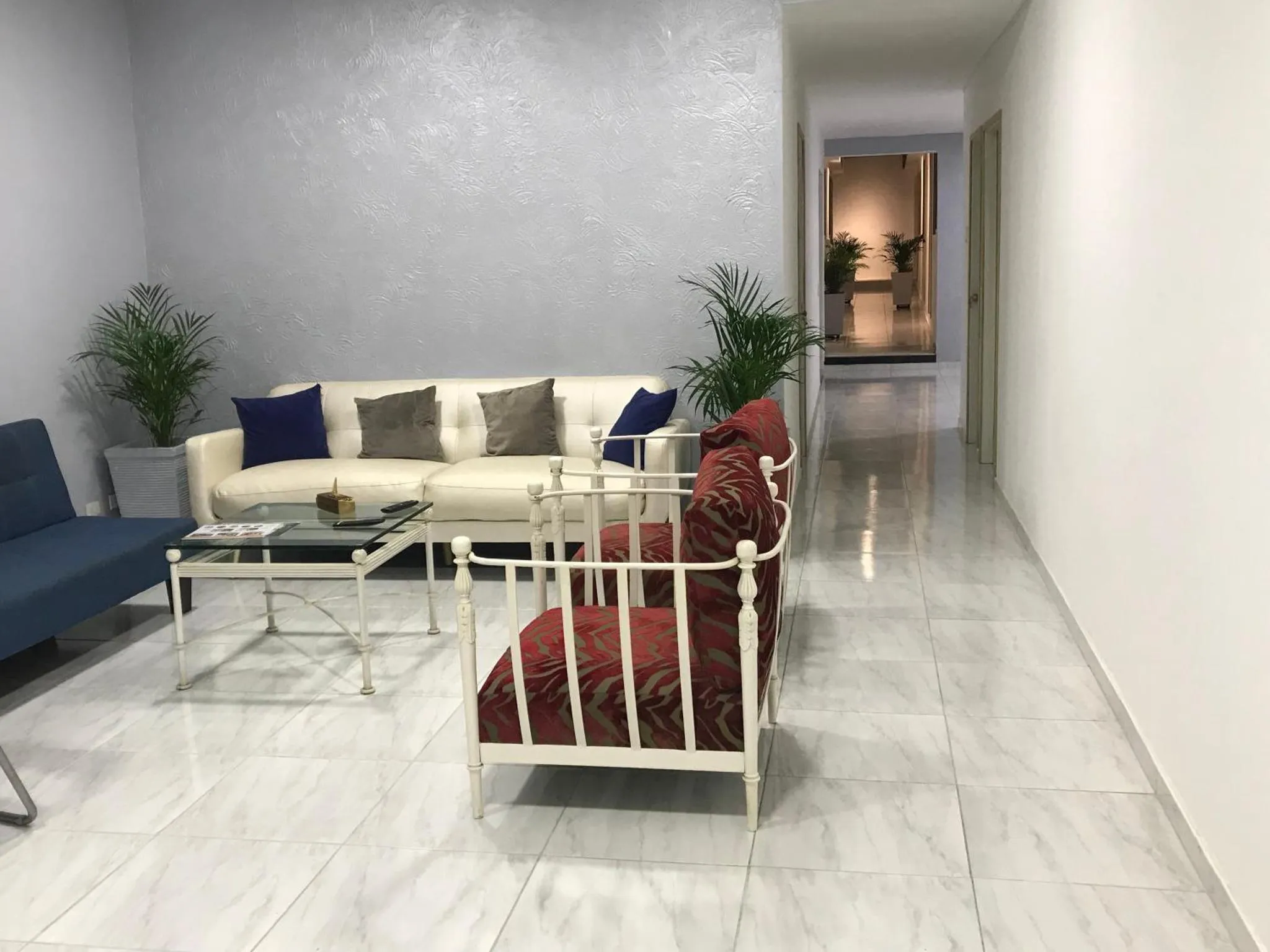 Un salon clair avec canapés et fauteuils.