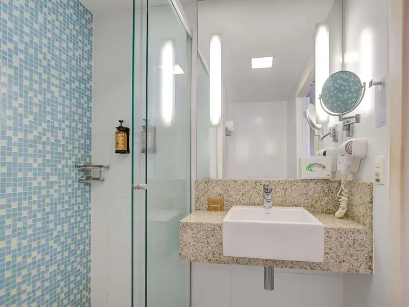 Une salle de bain lumineuse avec une douche à l'italienne et un lavabo.