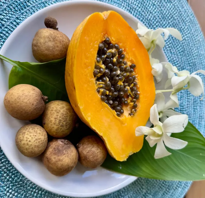 Une assiette de fruits exotiques colorés est présentée sur une table.
