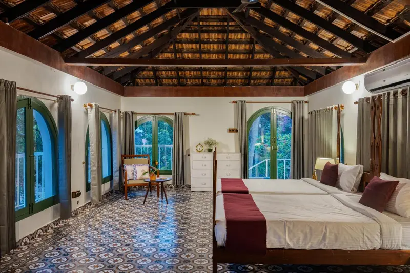 Une chambre lumineuse avec deux lits et un carrelage au sol.