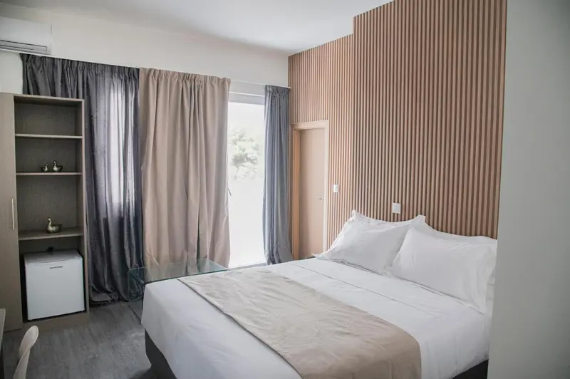 Une chambre lumineuse avec un grand lit et un mur texturé.