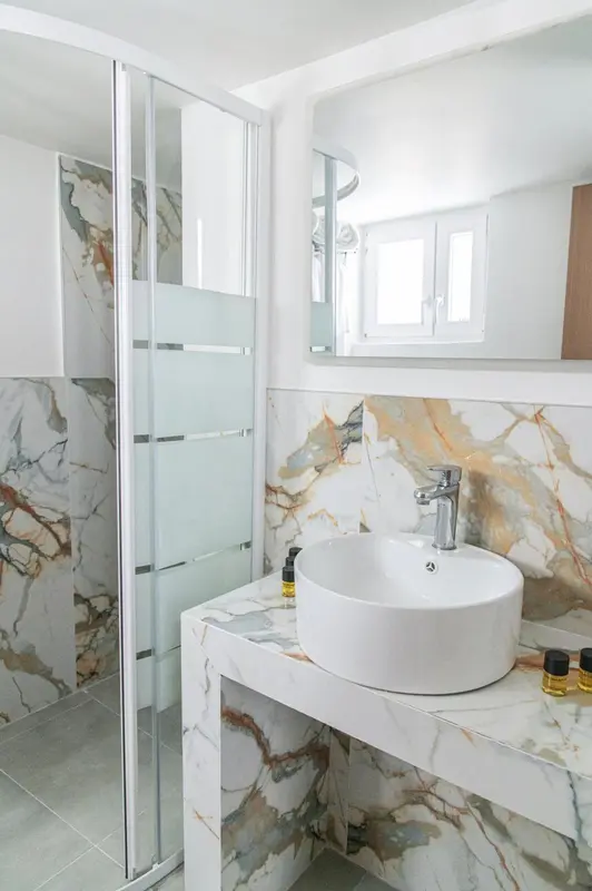 Une salle de bain moderne avec une douche vitrée et un lavabo sur un meuble.