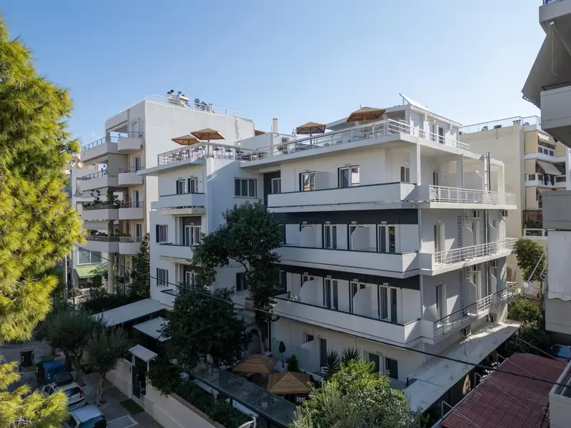 Bâtiment blanc à plusieurs étages avec des balcons et des terrasses.