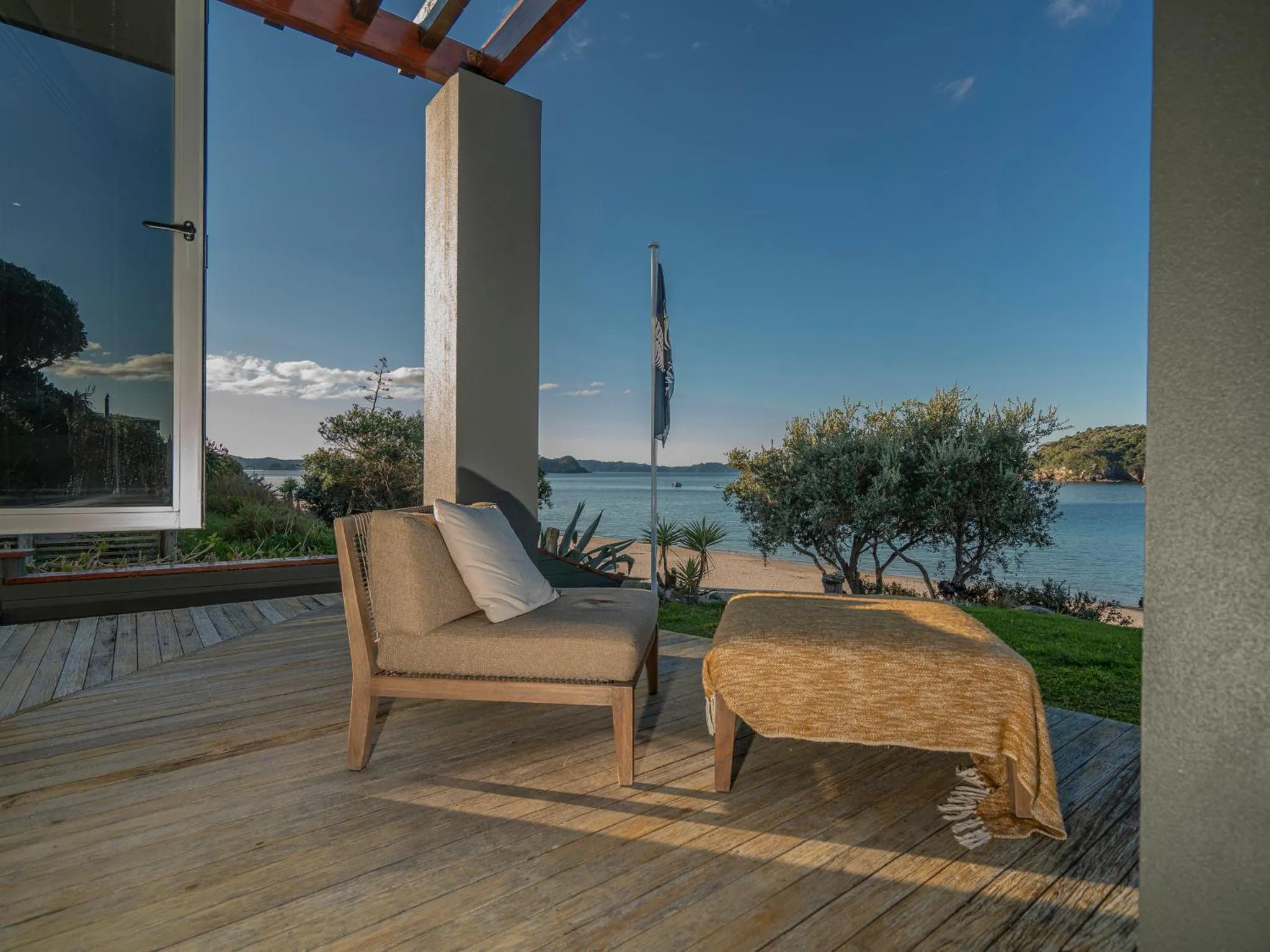 Terrasse en bois avec mobilier d'extérieur donnant sur la mer.