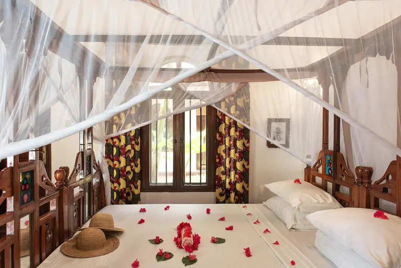 Lit à baldaquin dans une chambre décorée de fleurs.