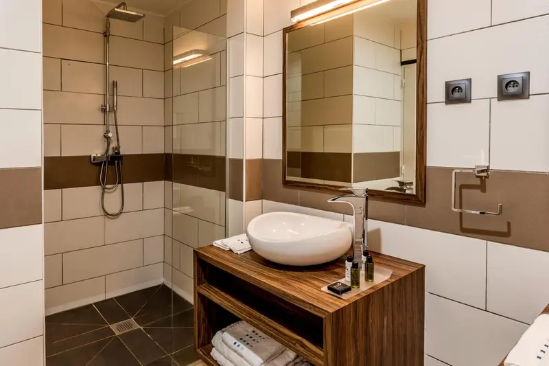 Une salle de bain moderne avec douche à l'italienne et vasque sur meuble.