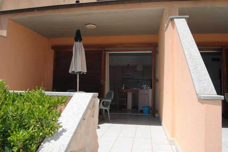 Terrasse avec cuisine visible à l'intérieur d'un logement.