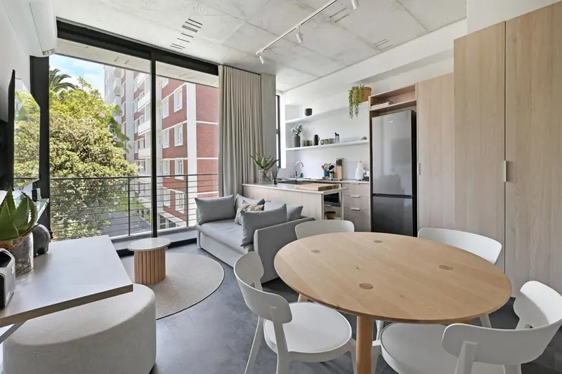 Espace de vie lumineux avec coin repas et cuisine ouverte.