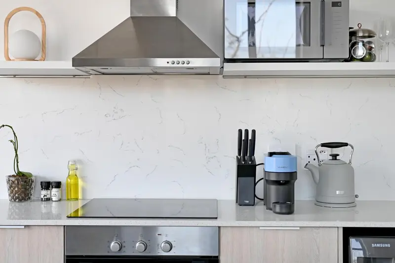 Une cuisine moderne avec des appareils en acier inoxydable et un plan de travail clair.