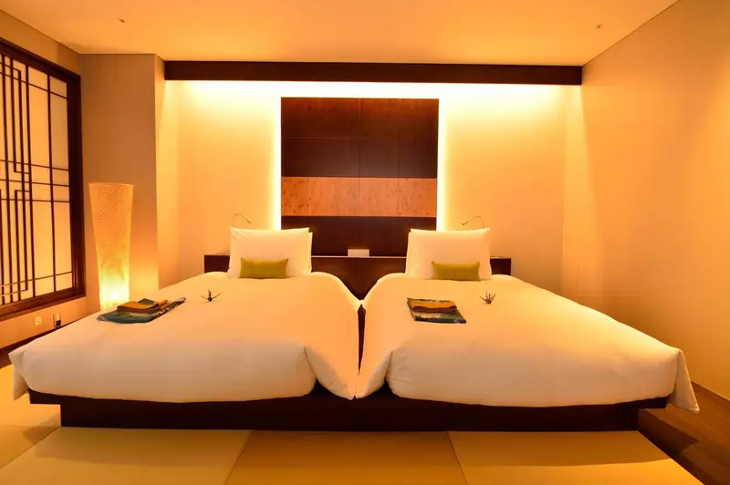 Une chambre lumineuse avec deux lits simples et une décoration sobre.