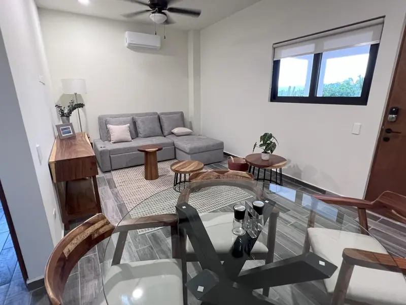 Un espace de vie intérieur avec un canapé, une table basse et une table à manger.