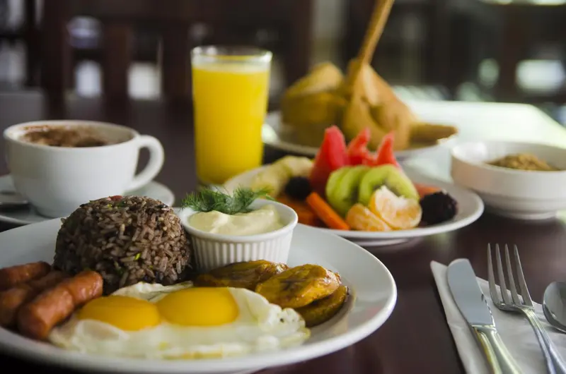 Un petit-déjeuner copieux est présenté sur une table en bois sombre.