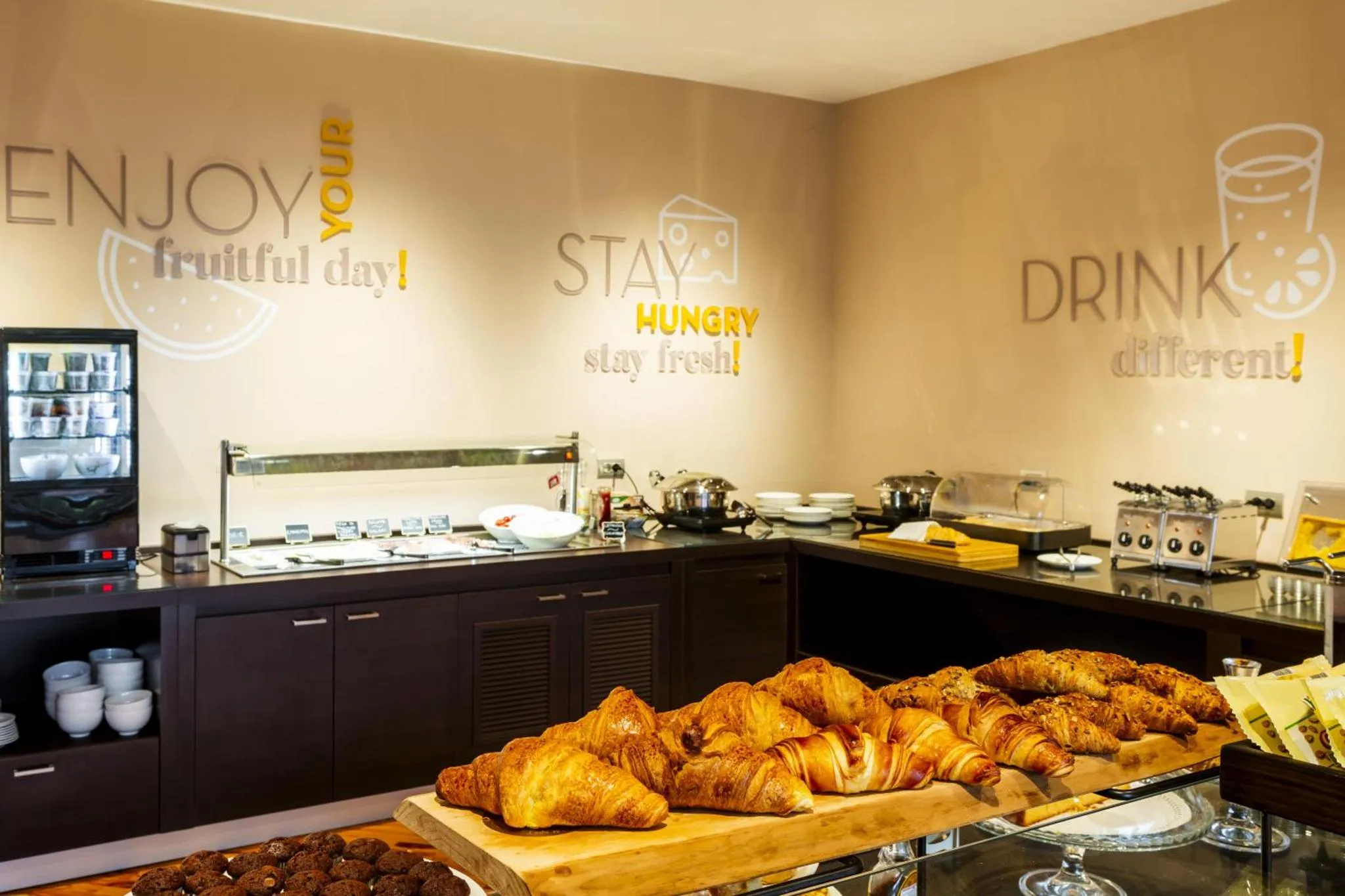 Un comptoir de buffet propose des viennoiseries et des boissons.
