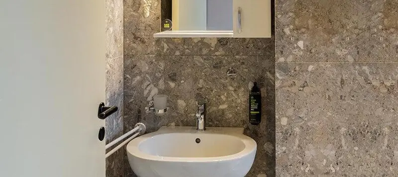 Un lavabo blanc est installé dans une salle de bain carrelée.