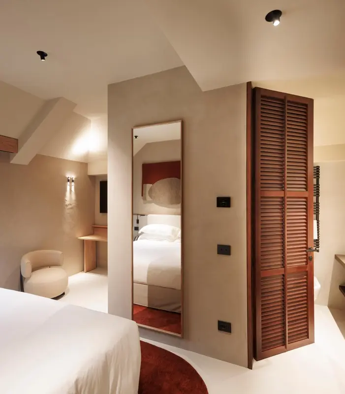 Une chambre à coucher lumineuse avec un lit et un miroir.