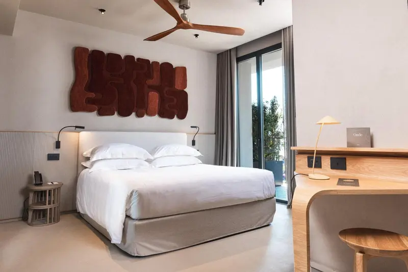 Une chambre lumineuse avec un grand lit et une décoration murale originale.