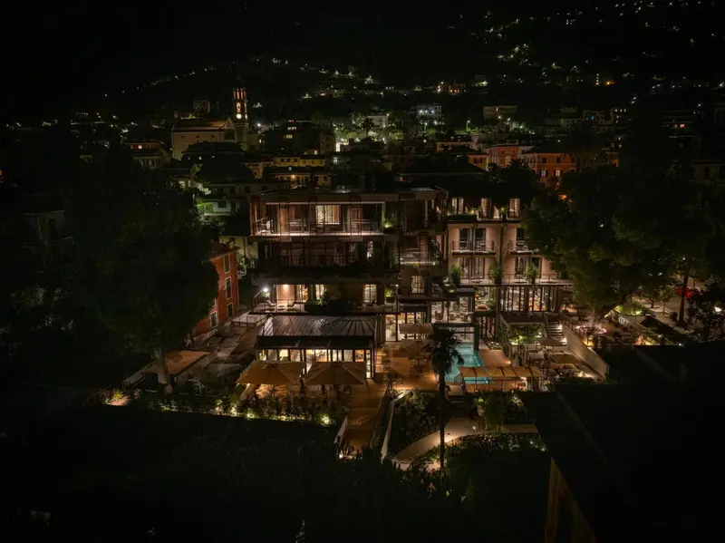 Vue nocturne d'un ensemble immobilier illuminé sur une colline.