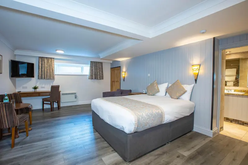 Une chambre lumineuse avec un grand lit et un espace détente.