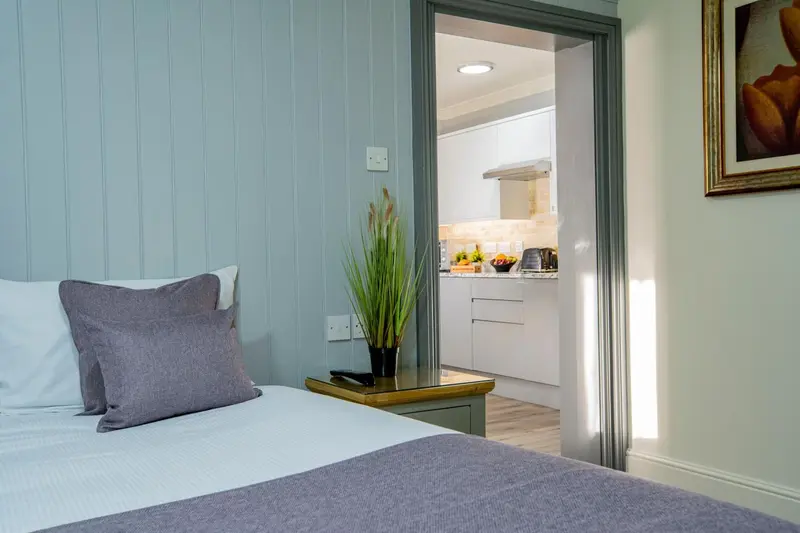 Une chambre avec un lit et un accès à une cuisine.