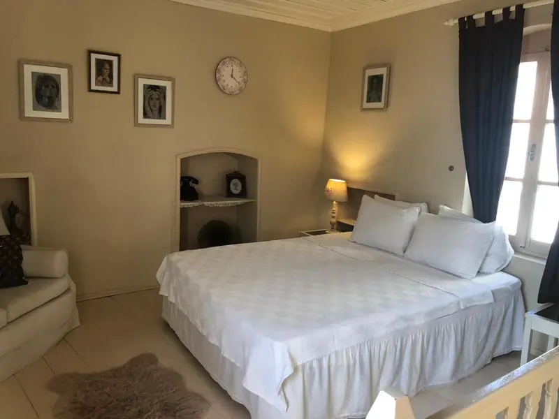 Une chambre lumineuse avec un grand lit recouvert de draps blancs.