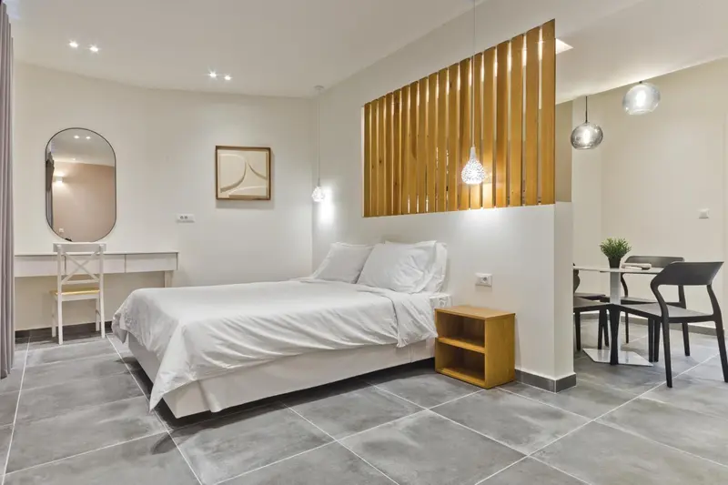 Une chambre lumineuse avec un lit et un coin repas.