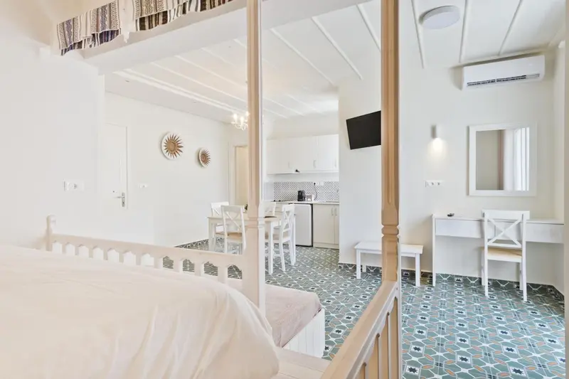 Une chambre lumineuse avec un lit à baldaquin et un espace repas.