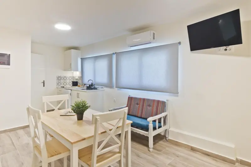 Une salle à manger lumineuse avec une kitchenette et un coin salon.