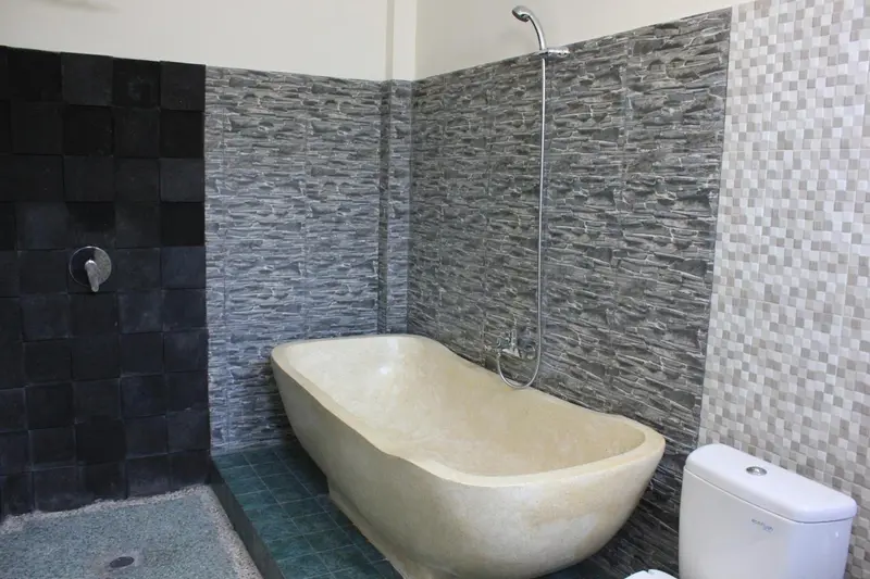 Une baignoire sur pied se trouve dans une salle de bain carrelée.